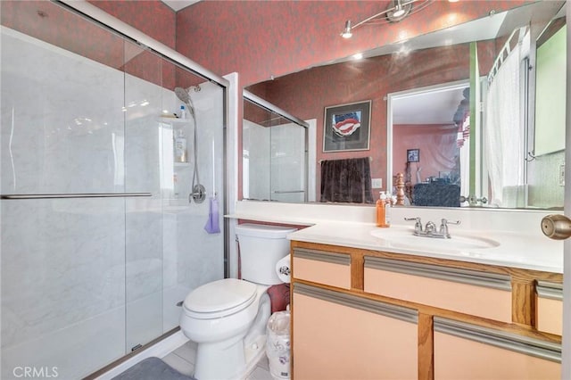 bathroom with vanity, a shower with door, and toilet