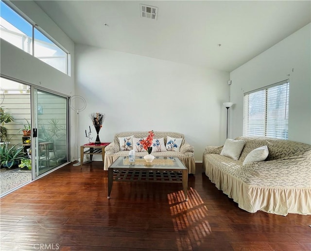 living room with dark hardwood / wood-style flooring, plenty of natural light, and high vaulted ceiling