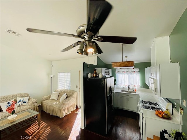 kitchen with dark wood-type flooring, white appliances, and a wealth of natural light