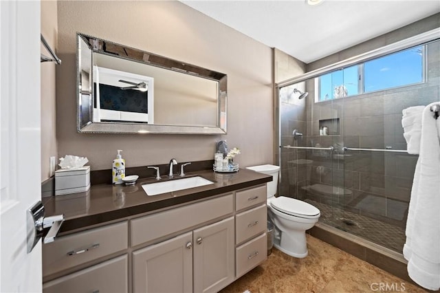 bathroom with vanity, toilet, and a shower with door