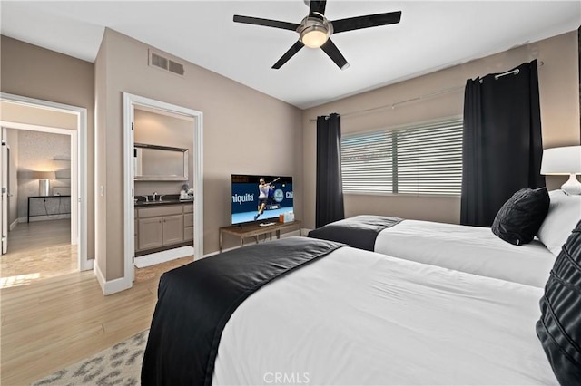 bedroom with connected bathroom, ceiling fan, sink, and light hardwood / wood-style floors