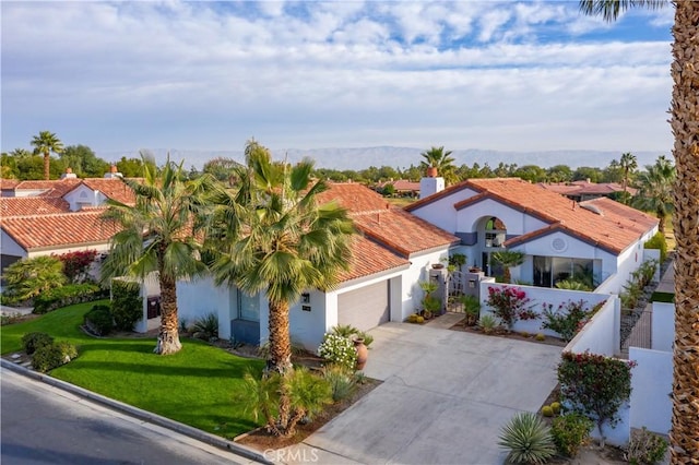 mediterranean / spanish house with a front lawn and a garage