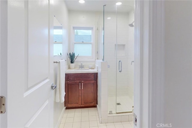 bathroom with tile patterned floors, vanity, and walk in shower