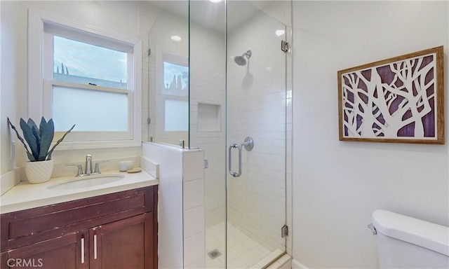 bathroom with vanity, a shower with shower door, and toilet