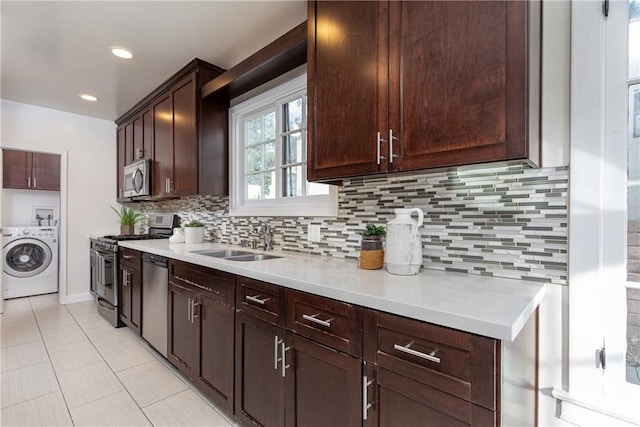 kitchen featuring appliances with stainless steel finishes, tasteful backsplash, dark brown cabinets, sink, and washer / clothes dryer