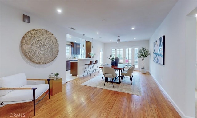 dining space with ceiling fan and light wood-type flooring