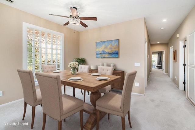 carpeted dining room featuring ceiling fan