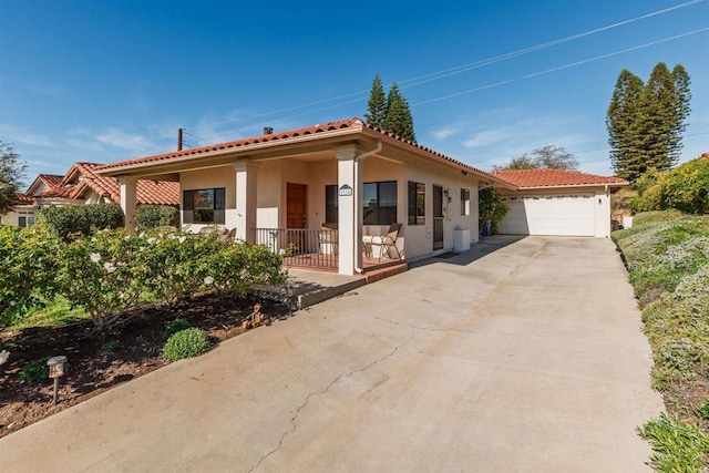 mediterranean / spanish home featuring covered porch and a garage