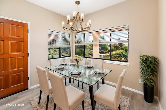 dining room with a wealth of natural light, light hardwood / wood-style flooring, and a notable chandelier