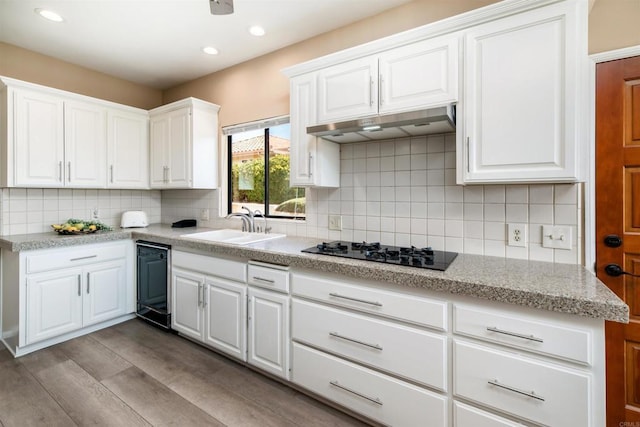 kitchen featuring light hardwood / wood-style flooring, white cabinets, black gas stovetop, and sink