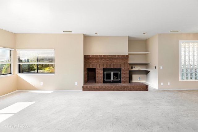 unfurnished living room with built in shelves, carpet flooring, and a fireplace