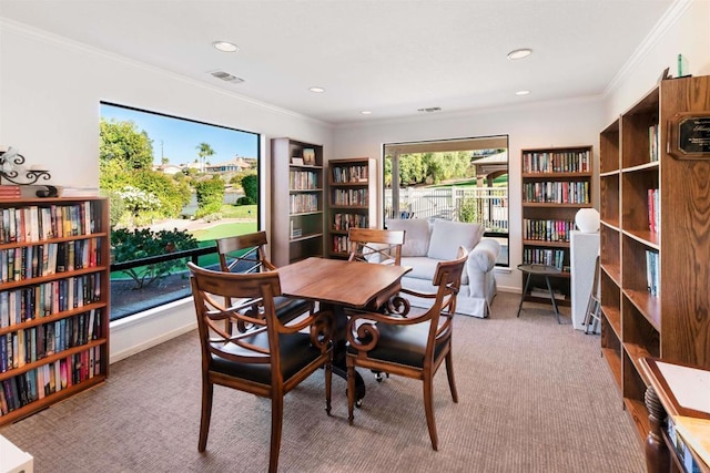 dining space with crown molding, built in features, and light colored carpet