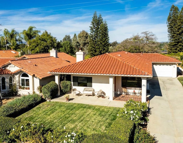 mediterranean / spanish house featuring a patio, a front lawn, an outdoor hangout area, and a garage