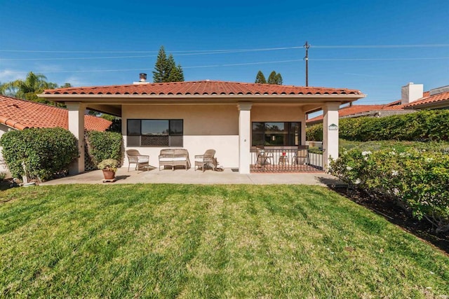 back of house with a lawn and a patio area