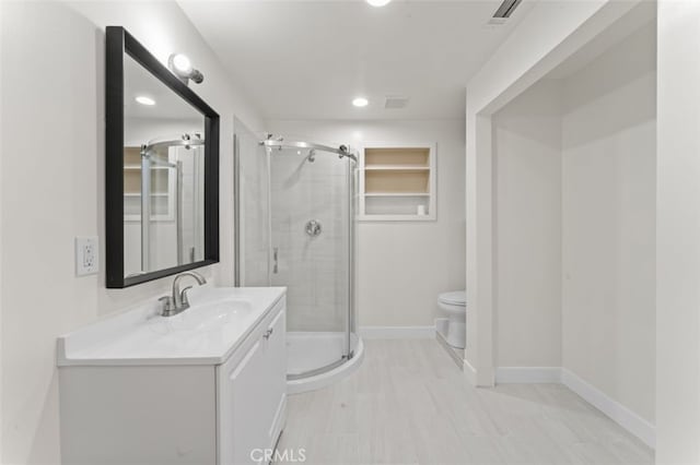 bathroom featuring an enclosed shower, vanity, and toilet