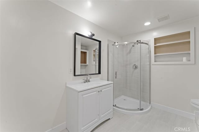 bathroom featuring toilet, a shower with door, and vanity