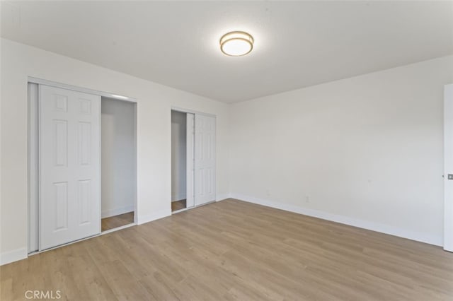 unfurnished bedroom with a textured ceiling and light wood-type flooring