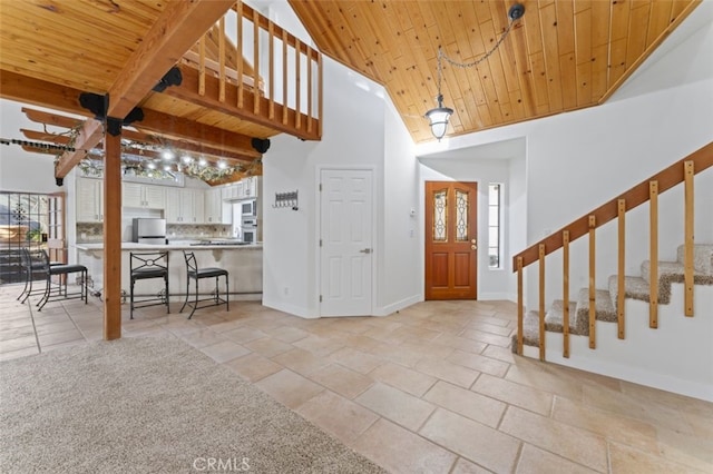 foyer entrance featuring high vaulted ceiling, plenty of natural light, beam ceiling, and wood ceiling