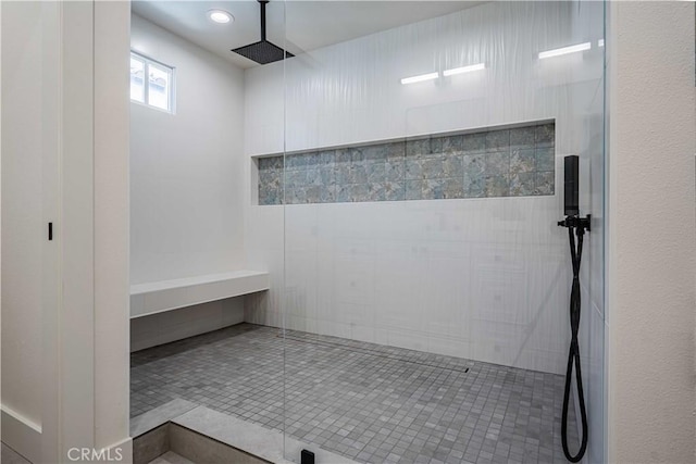 bathroom featuring tile patterned flooring and tiled shower