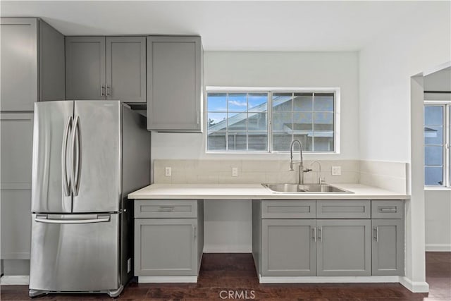 kitchen featuring gray cabinets, decorative backsplash, sink, dark wood-type flooring, and stainless steel fridge