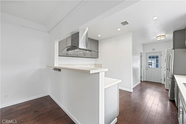 kitchen featuring kitchen peninsula, stainless steel fridge, island range hood, and gray cabinetry