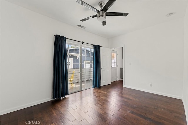 empty room with ceiling fan and dark hardwood / wood-style flooring