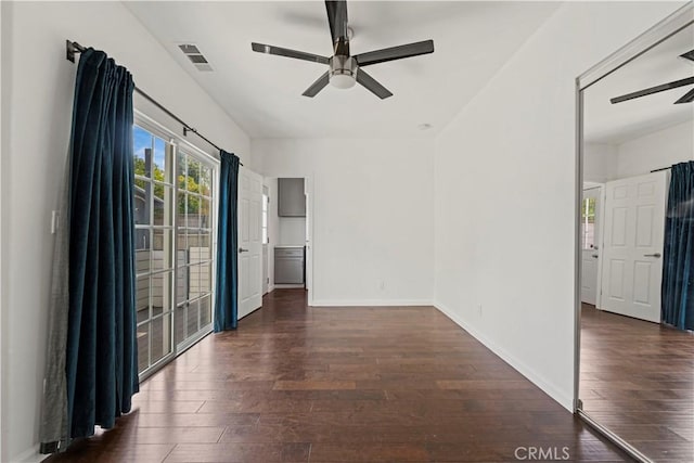 spare room with dark wood-type flooring and ceiling fan