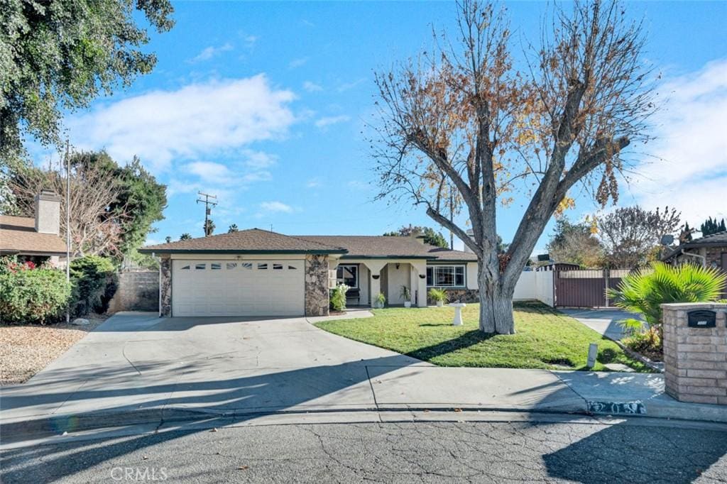 ranch-style house featuring a garage and a front yard