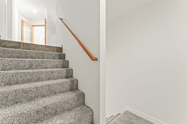 stairway featuring carpet flooring