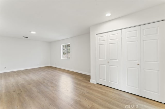 unfurnished bedroom featuring a closet and light wood-type flooring