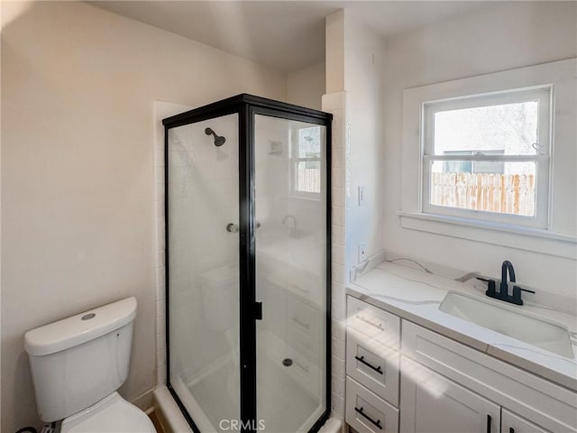 bathroom with walk in shower, vanity, and toilet