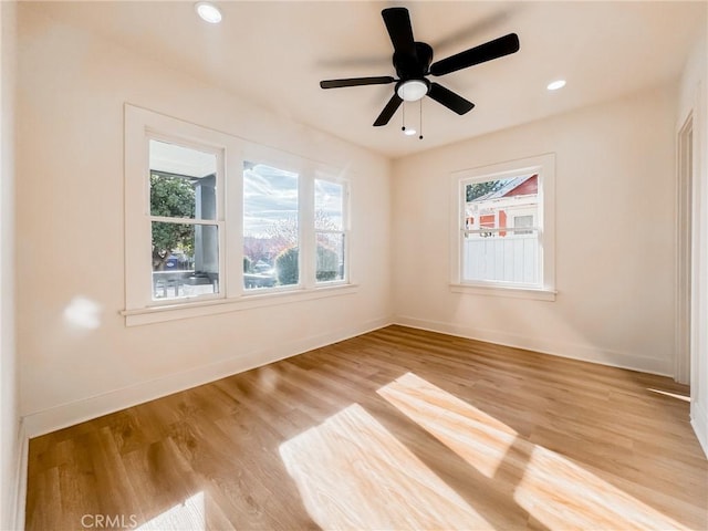 empty room with ceiling fan and light hardwood / wood-style flooring