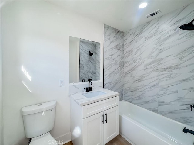 full bathroom with toilet, vanity, and tiled shower / bath