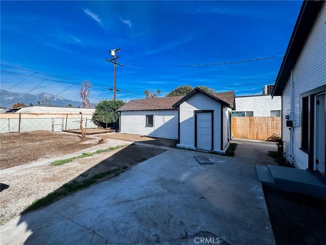 exterior space with a storage shed, a mountain view, and a patio