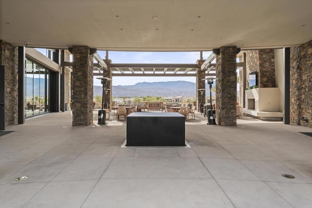 view of patio / terrace featuring an outdoor stone fireplace and a pergola