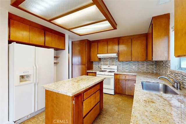 kitchen with light stone countertops, sink, a center island, tasteful backsplash, and white appliances