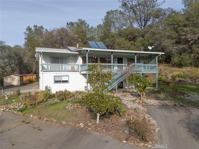 view of front of property featuring covered porch and solar panels