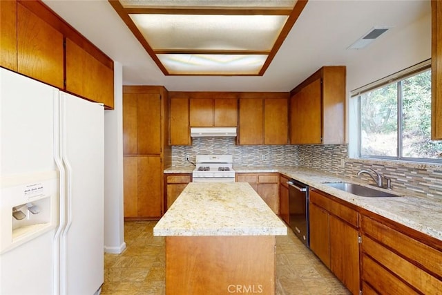 kitchen featuring light stone countertops, tasteful backsplash, white appliances, sink, and a center island