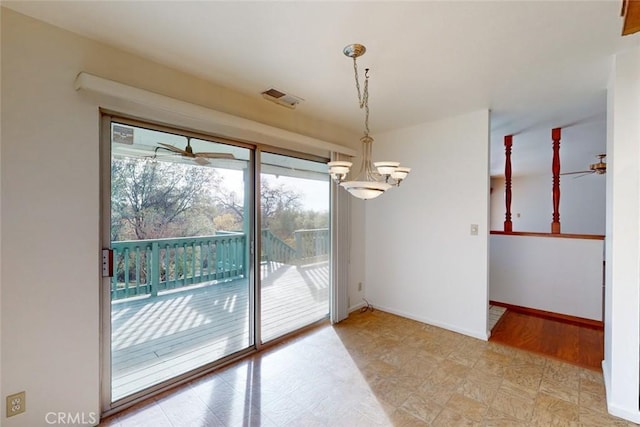 unfurnished dining area featuring ceiling fan with notable chandelier