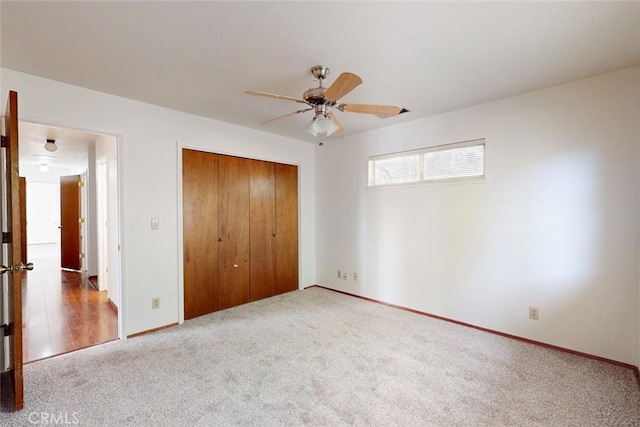 unfurnished bedroom featuring carpet, a closet, and ceiling fan