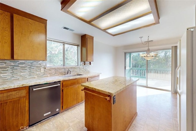 kitchen featuring dishwasher, a healthy amount of sunlight, a kitchen island, and sink