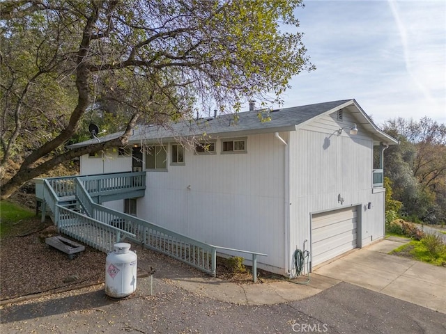 view of property exterior with a garage and a deck