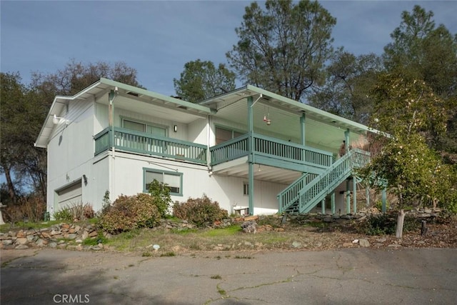 view of home's exterior featuring a porch, a balcony, and a garage