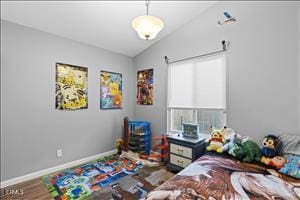 bedroom with hardwood / wood-style floors and vaulted ceiling