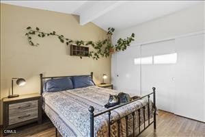 bedroom featuring hardwood / wood-style flooring and lofted ceiling with beams