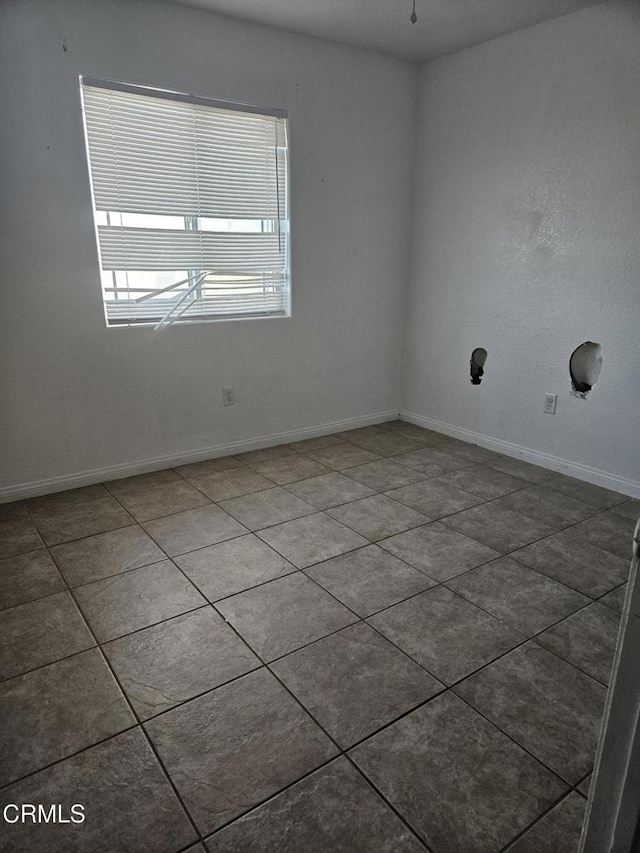 unfurnished room featuring dark tile patterned flooring