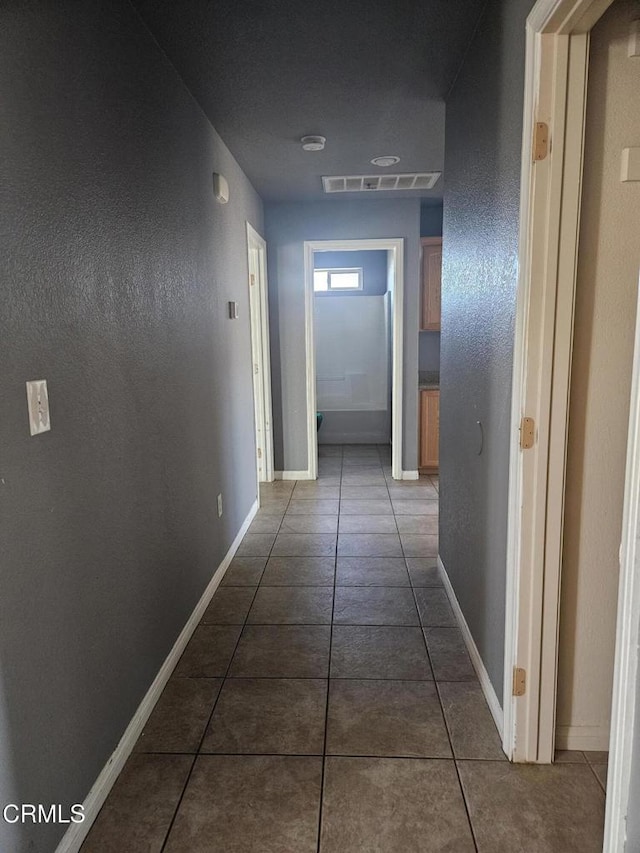 corridor featuring dark tile patterned floors