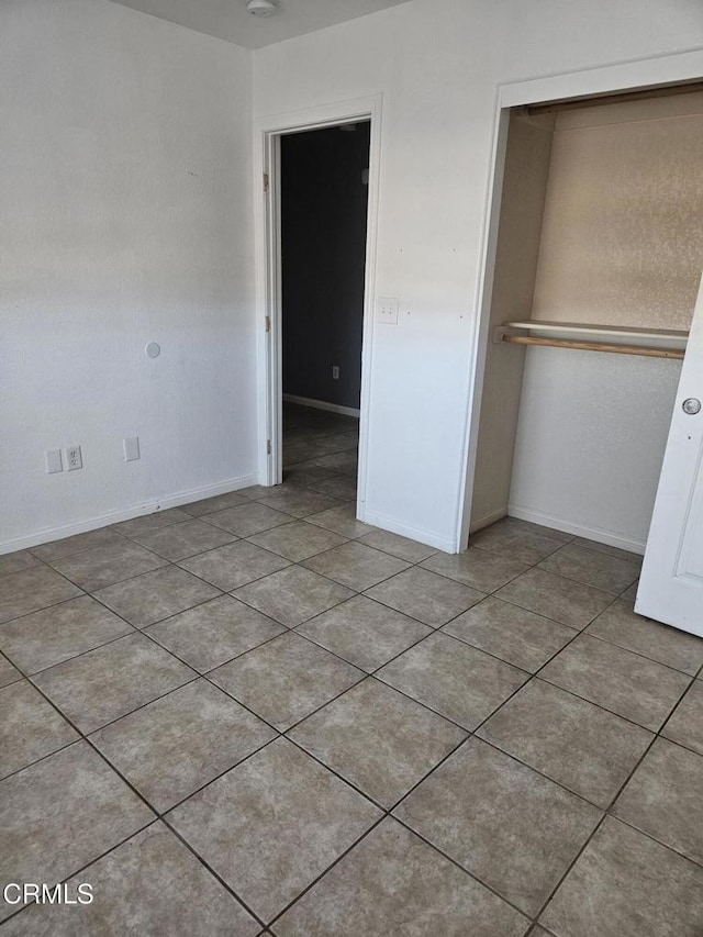 unfurnished bedroom featuring light tile patterned floors and a closet