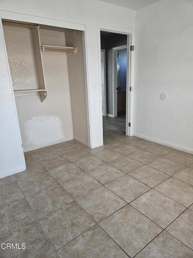 unfurnished bedroom featuring a closet and light tile patterned flooring