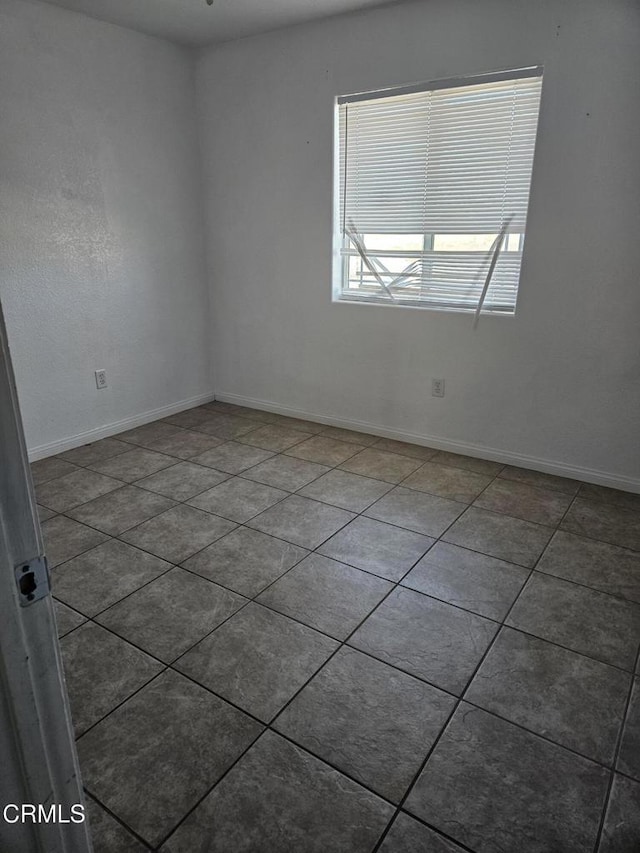 empty room featuring dark tile patterned flooring